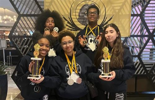  students holding metals and trophies 